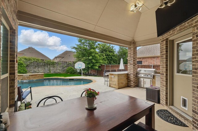 view of pool with area for grilling, a fenced backyard, a patio area, grilling area, and an outdoor bar