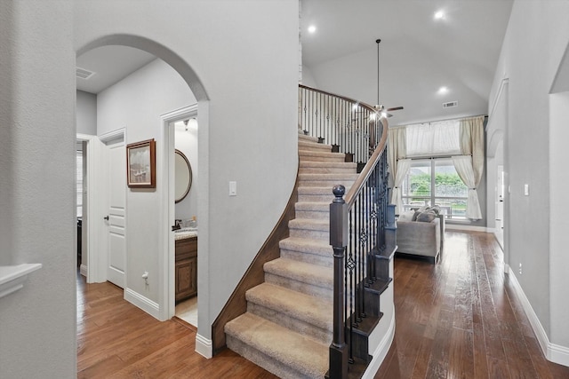 stairs with arched walkways, hardwood / wood-style floors, baseboards, recessed lighting, and ceiling fan
