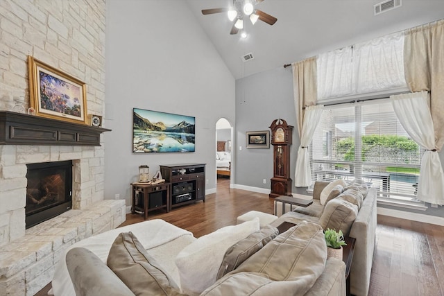 living room featuring high vaulted ceiling, a ceiling fan, wood finished floors, arched walkways, and baseboards