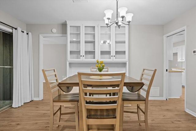 3205 Creekwood Cir, Waco, TX 76710 - dining room featuring a chandelier, light wood-style floors, and baseboards