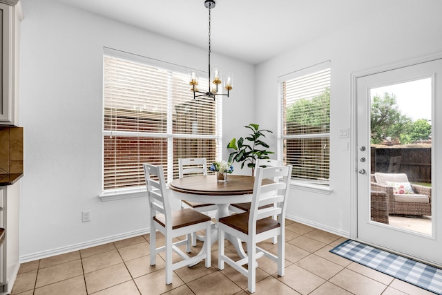 dining area featuring a chandelier, light tile patterned floors, and baseboards