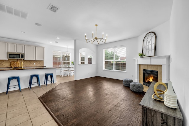 living room with a chandelier, a fireplace, light tile patterned floors, recessed lighting, and baseboards