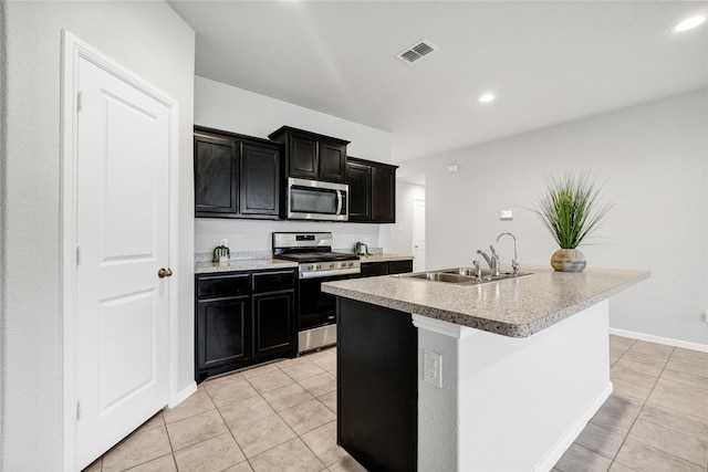 16509 Portage St, Justin, TX 76247 - kitchen with appliances with stainless steel finishes, a sink, light tile patterned floors, dark cabinetry, and recessed lighting