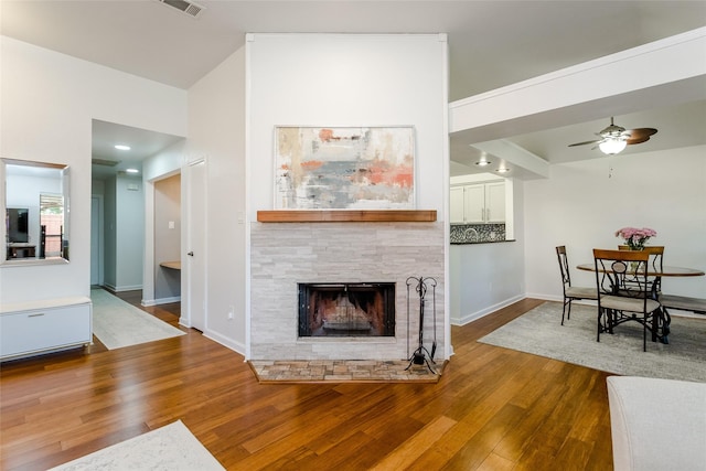 3841 Beaumont Ln, Plano, TX 75023 - living area featuring ceiling fan, wood finished floors, a stone fireplace, and baseboards