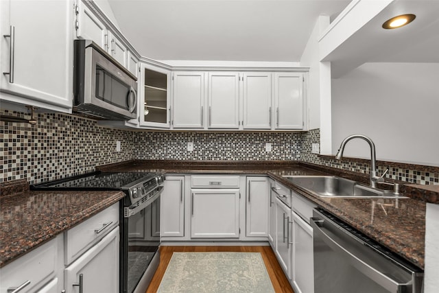 3841 Beaumont Ln, Plano, TX 75023 - kitchen with stainless steel appliances, a sink, dark wood finished floors, decorative backsplash, and dark stone counters