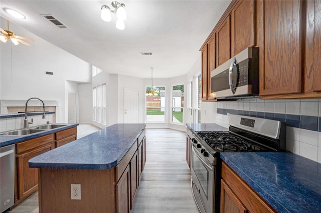 kitchen featuring stainless steel appliances, a sink, dark countertops, and decorative backsplash