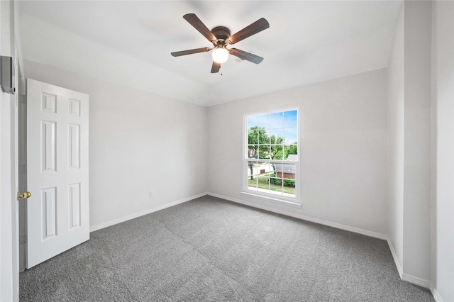 carpeted spare room with a ceiling fan and baseboards