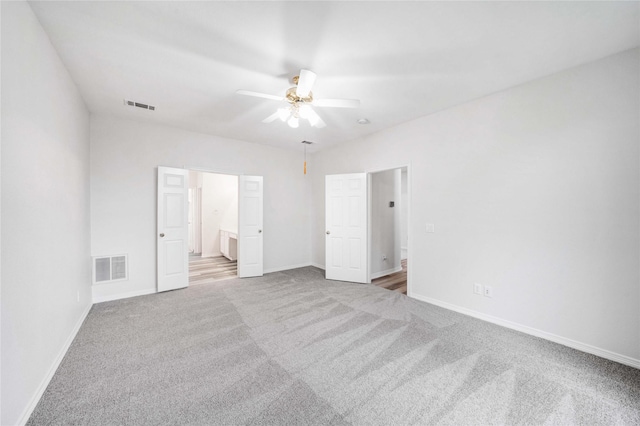unfurnished bedroom featuring carpet, baseboards, and ensuite bath