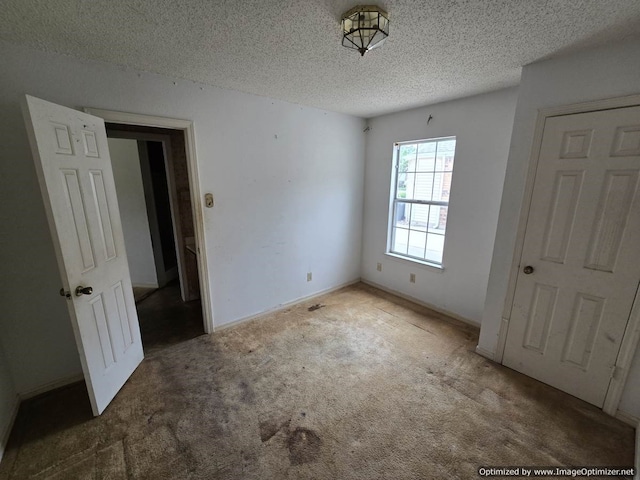 4115 Hollow Oak Dr, Dallas, TX 75287 - unfurnished bedroom with a textured ceiling, carpet, and baseboards