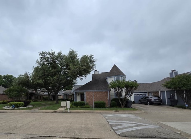 4115 Hollow Oak Dr, Dallas, TX 75287 - view of front of home featuring brick siding, concrete driveway, and a chimney