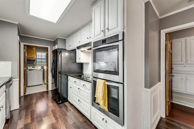 kitchen with black appliances, white cabinetry, ornamental molding, dark wood finished floors, and under cabinet range hood