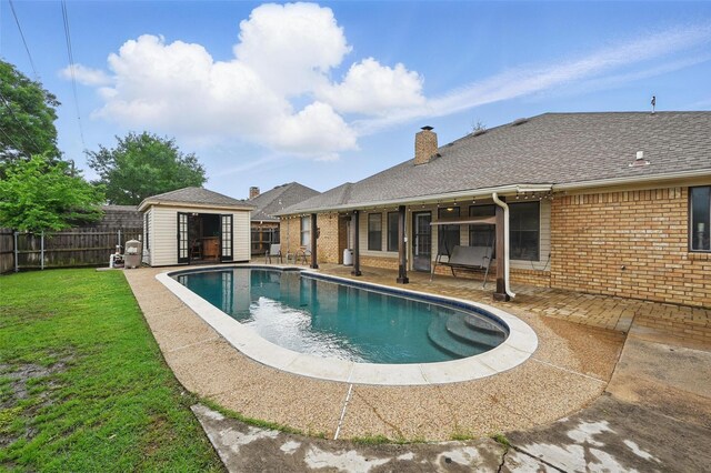 view of pool with a storage shed, an outbuilding, and a patio