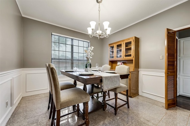 dining area with a decorative wall, a chandelier, wainscoting, and ornamental molding