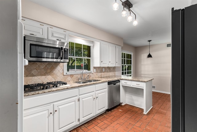 6838 Lupton Dr, Dallas, TX 75225 - kitchen featuring stainless steel appliances, a sink, white cabinetry, and brick patterned flooring