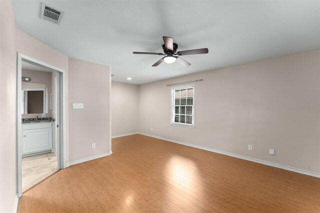 6838 Lupton Dr, Dallas, TX 75225 - spare room featuring a ceiling fan, light wood finished floors, baseboards, and a sink
