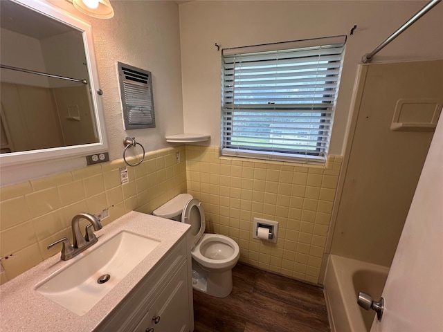 1664 Poplar Dr, Mesquite, TX 75149 - full bath featuring tile walls, wood finished floors, toilet, vanity, and a wainscoted wall