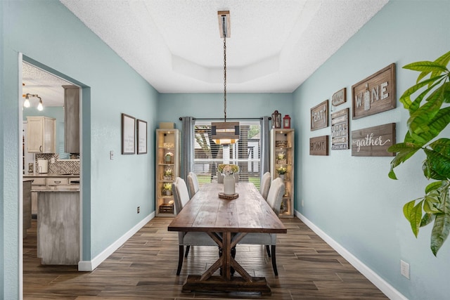 7012 Fox Dr, The Colony, TX 75056 - dining area with a raised ceiling, a chandelier, dark wood finished floors, baseboards, and a textured ceiling
