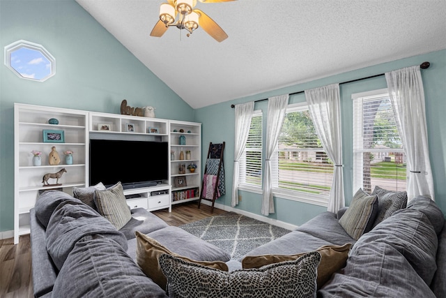 7012 Fox Dr, The Colony, TX 75056 - living area featuring wood finished floors, ceiling fan, plenty of natural light, baseboards, and lofted ceiling