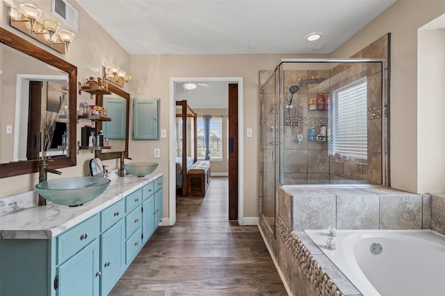 7012 Fox Dr, The Colony, TX 75056 - bathroom with ensuite bathroom, a stall shower, a garden tub, double vanity, and wood finished floors