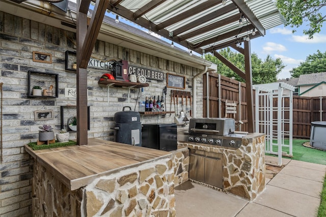 7012 Fox Dr, The Colony, TX 75056 - view of patio featuring an outdoor kitchen, grilling area, fence, a storage shed, and an outdoor structure