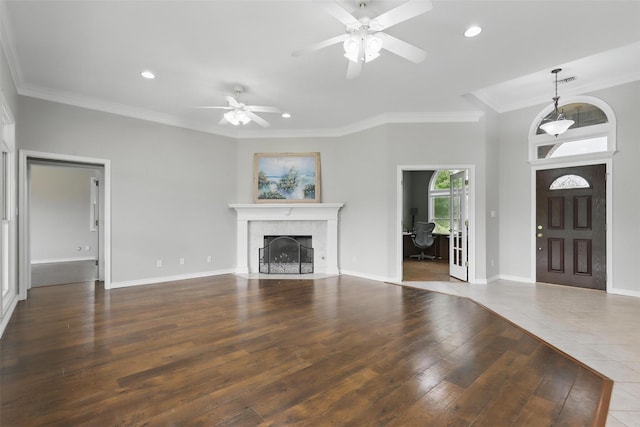 unfurnished living room with ceiling fan, ornamental molding, wood finished floors, a tile fireplace, and recessed lighting