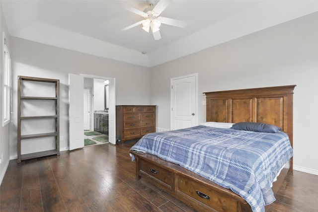 bedroom with dark wood-style flooring, baseboards, a ceiling fan, and connected bathroom