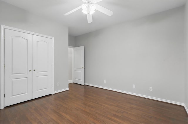 unfurnished bedroom with dark wood-style floors, baseboards, a closet, and ceiling fan
