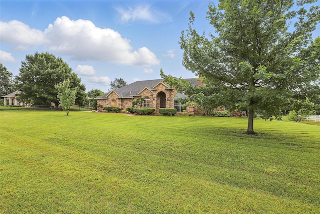 view of front facade featuring a front yard and brick siding