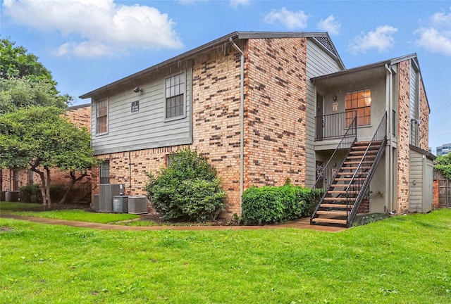 5335 Bent Tree Forest Dr Unit 240, Dallas, TX 75248 - view of side of property with brick siding, stairs, a yard, and cooling unit