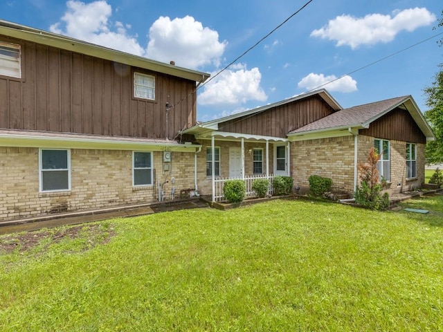 13134 Ravenview Rd, Dallas, TX 75253 - rear view of house with covered porch, a yard, and brick siding