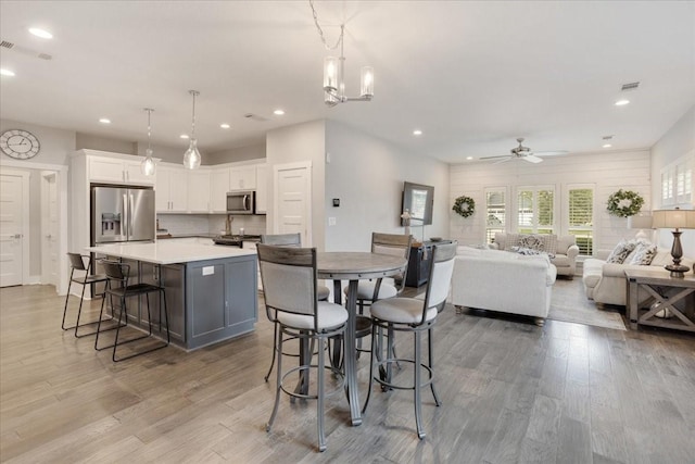 dining room featuring recessed lighting, light wood-style flooring, ceiling fan, and a chandelier