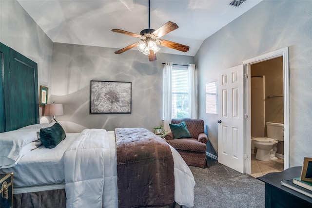 carpeted bedroom with vaulted ceiling, ensuite bath, ceiling fan, and tile patterned flooring