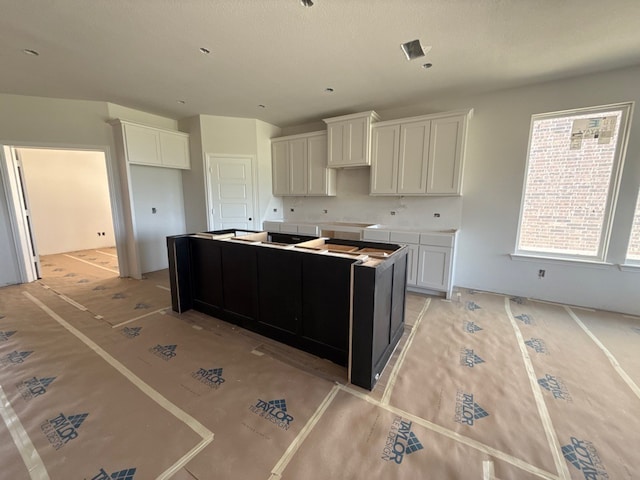 400 Tollett Dr, Aledo, TX 76008 - kitchen with a center island, white cabinets, and decorative backsplash