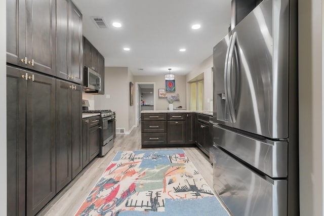 3809 Runge Ct E, Irving, TX 75038 - kitchen with stainless steel appliances, a peninsula, light wood-type flooring, light countertops, and baseboards