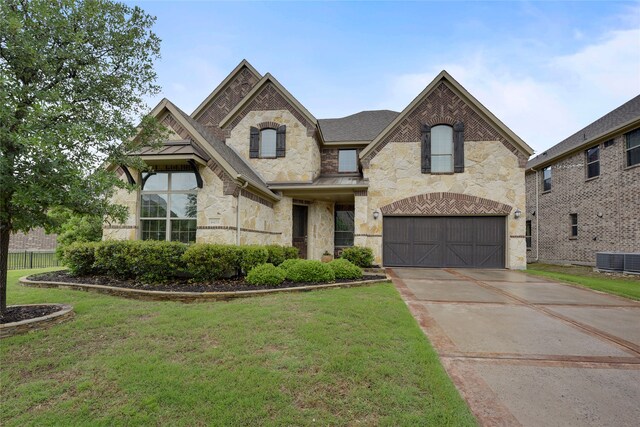 4458 Hartebeest Trl, Frisco, TX 75034 - french country style house featuring stone siding, cooling unit, concrete driveway, and a front lawn