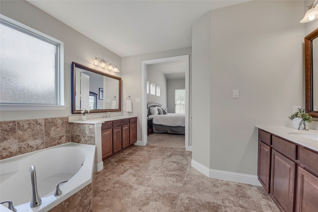 4458 Hartebeest Trl, Frisco, TX 75034 - ensuite bathroom featuring a bath, two vanities, and baseboards