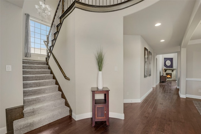 4458 Hartebeest Trl, Frisco, TX 75034 - staircase with wood-type flooring, baseboards, a chandelier, recessed lighting, and a lit fireplace