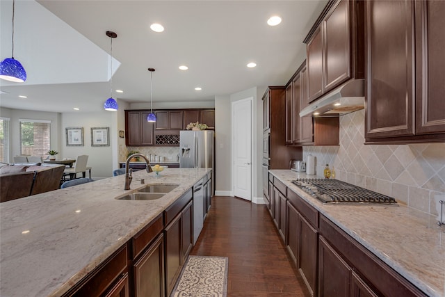 4458 Hartebeest Trl, Frisco, TX 75034 - kitchen with a sink, under cabinet range hood, stainless steel appliances, light stone counters, and tasteful backsplash
