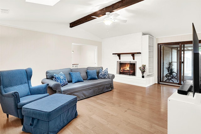 living area featuring wood finished floors, a brick fireplace, and ceiling fan
