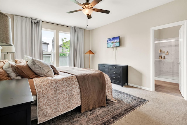 bedroom featuring carpet floors, baseboards, ensuite bathroom, and ceiling fan
