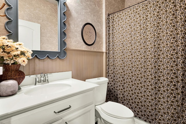 full bath with toilet, wainscoting, vanity, and curtained shower