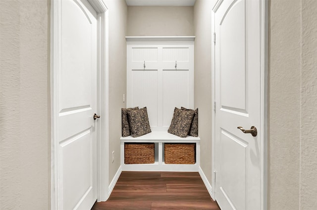 mudroom with dark wood-style flooring and baseboards