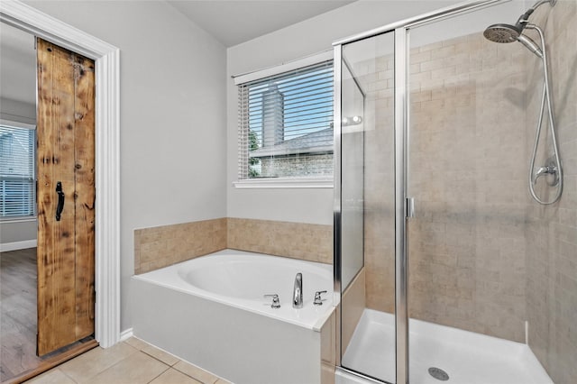 bathroom featuring a stall shower, a garden tub, and tile patterned flooring