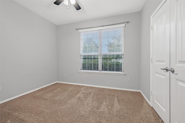 unfurnished room featuring carpet, a ceiling fan, and baseboards