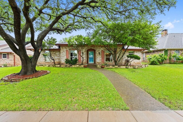 ranch-style home with brick siding and a front lawn