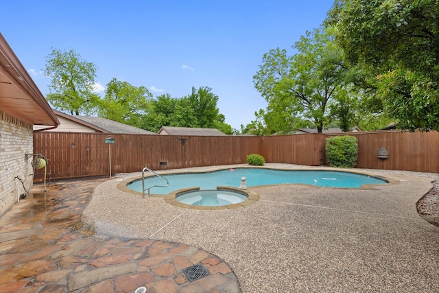 view of pool featuring a fenced backyard, a patio, and a pool with connected hot tub