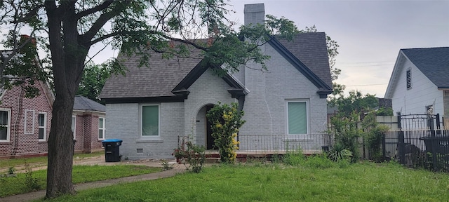 view of front of home featuring brick siding, a chimney, and roof with shingles