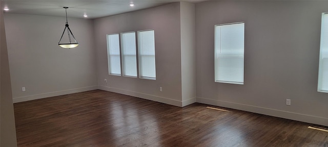 unfurnished room featuring baseboards, dark wood-type flooring, healthy amount of natural light, and recessed lighting
