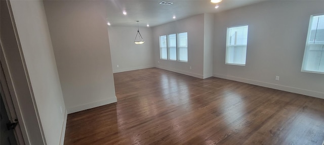 empty room featuring baseboards, dark wood-style floors, and recessed lighting