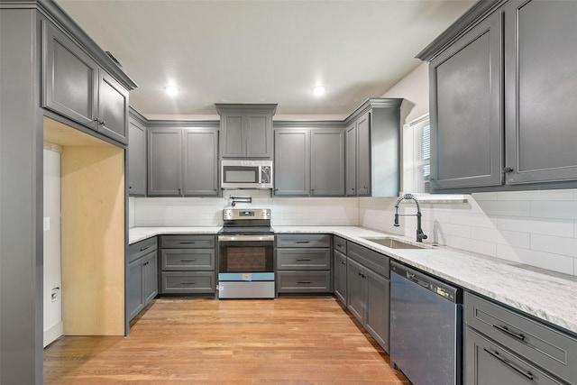 2735 S Jennings Ave, Fort Worth, TX 76110 - kitchen featuring appliances with stainless steel finishes, a sink, gray cabinets, tasteful backsplash, and recessed lighting